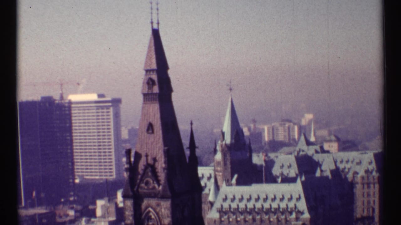 Ottawa skyline with Gothic spires and modern high-rise buildings under haze.