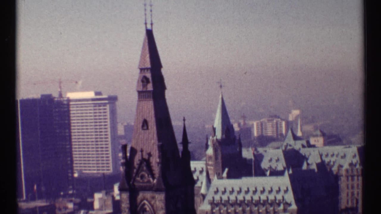 Similar skyline view with a tall Gothic spire, rooflines, and distant high-rises.