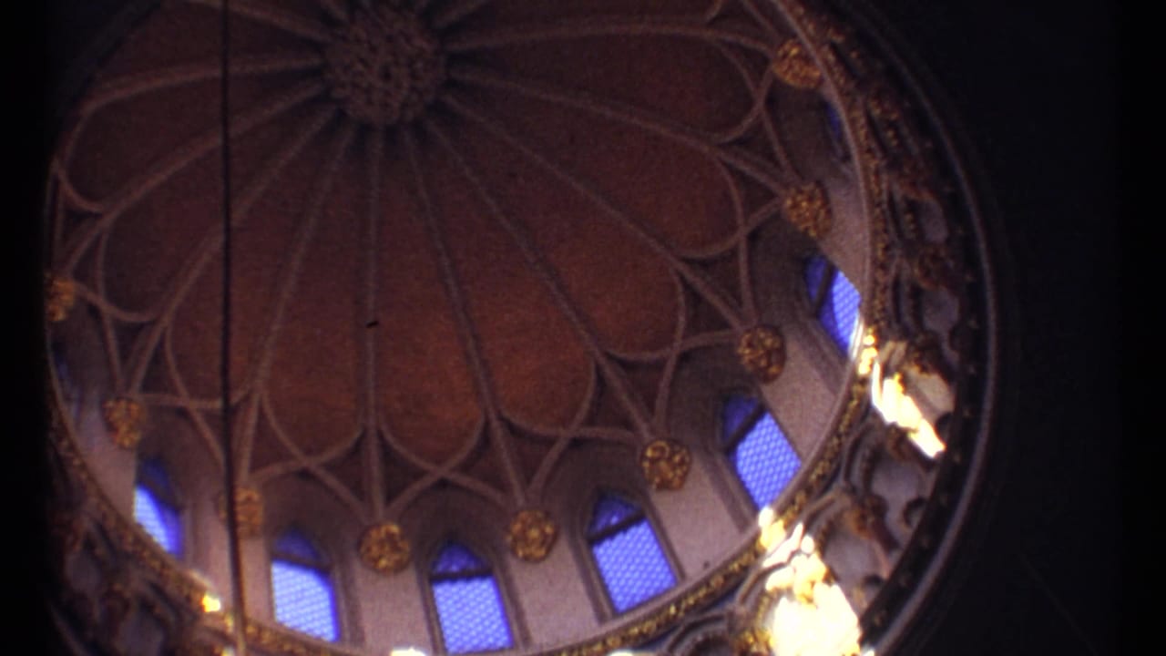 Ornate domed ceiling with ribbed pattern, gold details, and blue-lit arched windows.