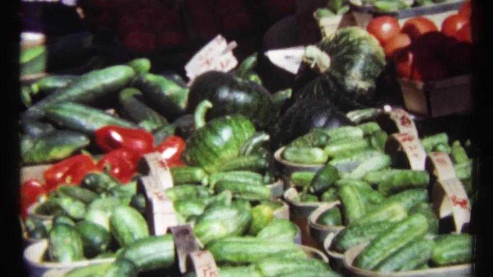 Close 1967 Ottawa market detail showing cucumbers, tomatoes, peppers, and handwritten price tags on a produce stand.