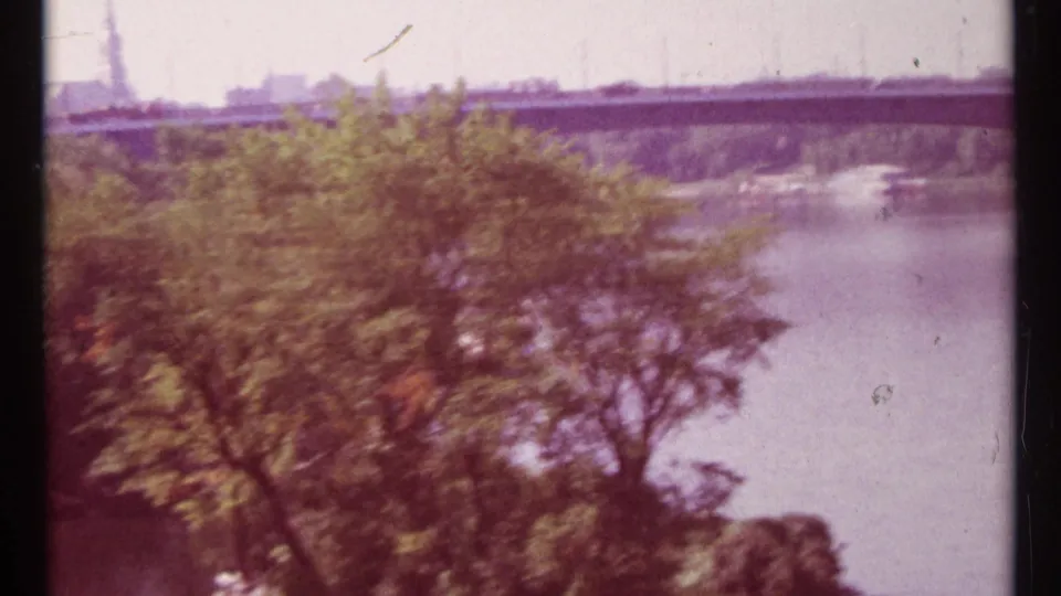 1967 Ottawa home-movie view of trees along the Ottawa River with a bridge crossing in the distance.