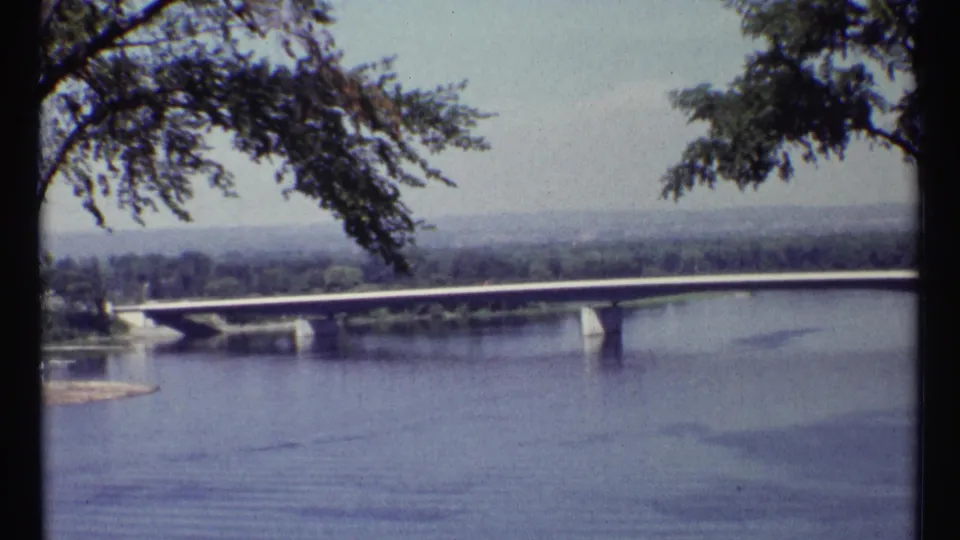 Ottawa river bridge in 1967 home-movie footage, viewed from a high overlook with branches entering the frame.