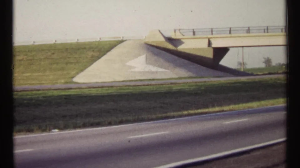 A 1967 Ottawa roadside view shows a concrete overpass, grass embankment, and asphalt lanes in warm 8mm color.