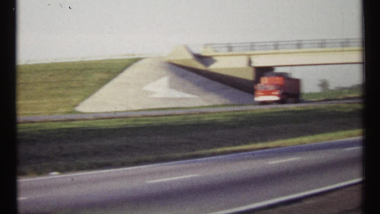 1967 Ottawa-area highway view with a red truck below a concrete overpass and green roadside slopes.