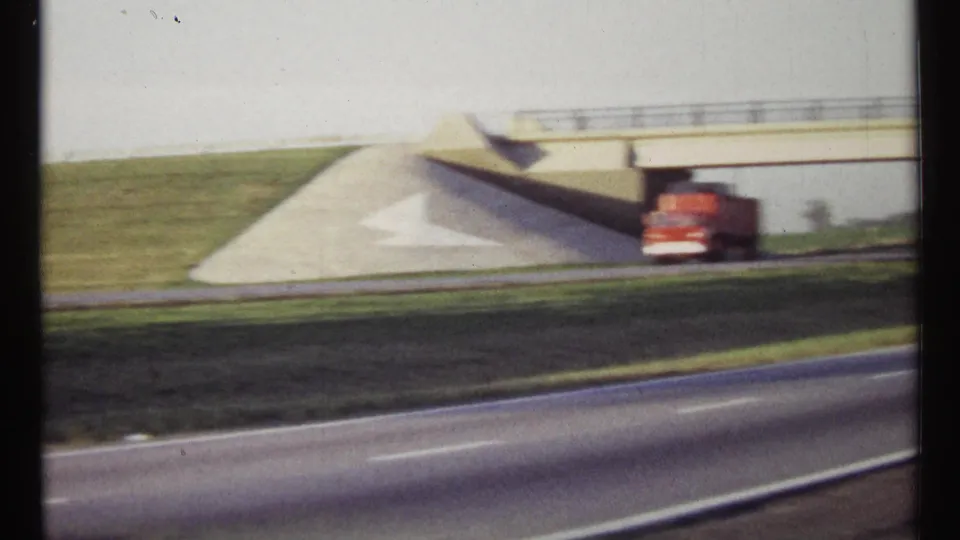 1967 Ottawa-area highway view with a red truck below a concrete overpass and green roadside slopes.