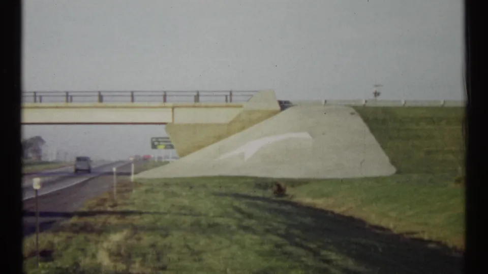 1967 Ottawa road scene with traffic below an overpass and a directional sign near the embankment leading toward Québec.