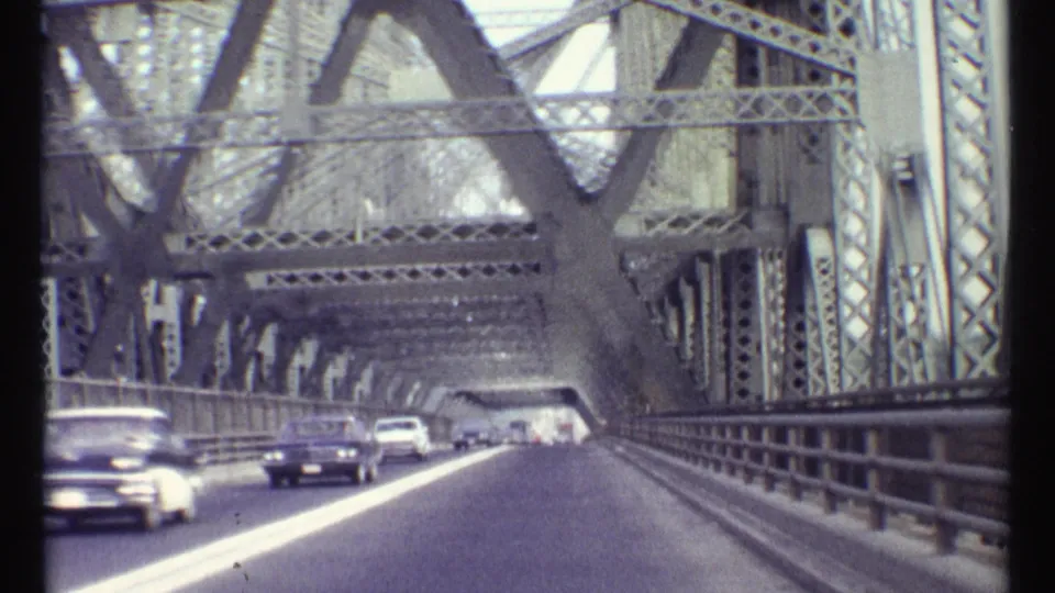 1967 Ottawa home-movie view looking forward through a steel truss bridge as classic cars approach in the opposite lane.