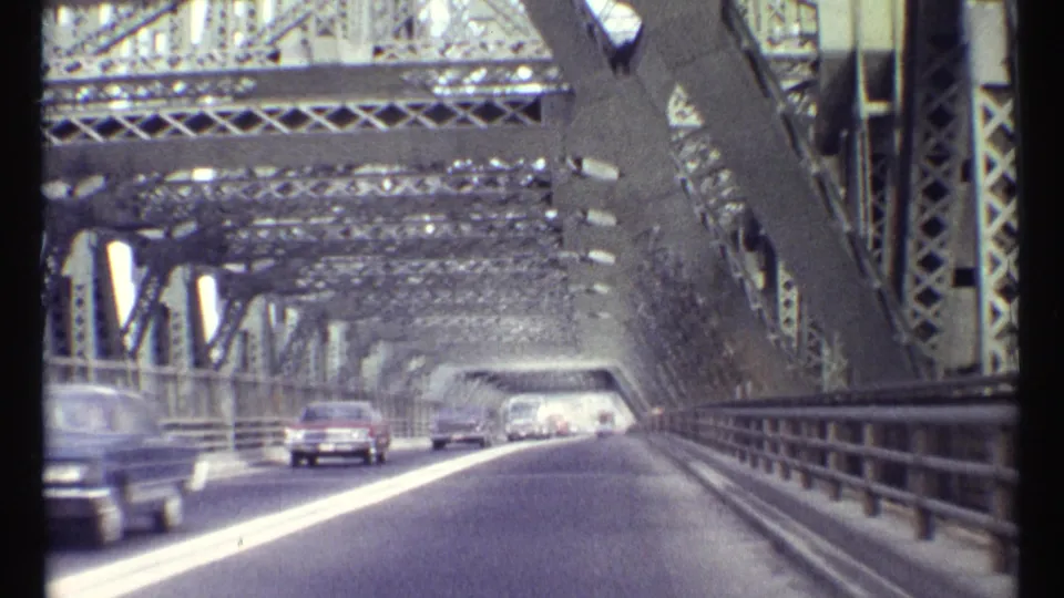 Forward 8mm view on the Ottawa steel truss bridge, with cars ahead and a red car approaching through the metal span.