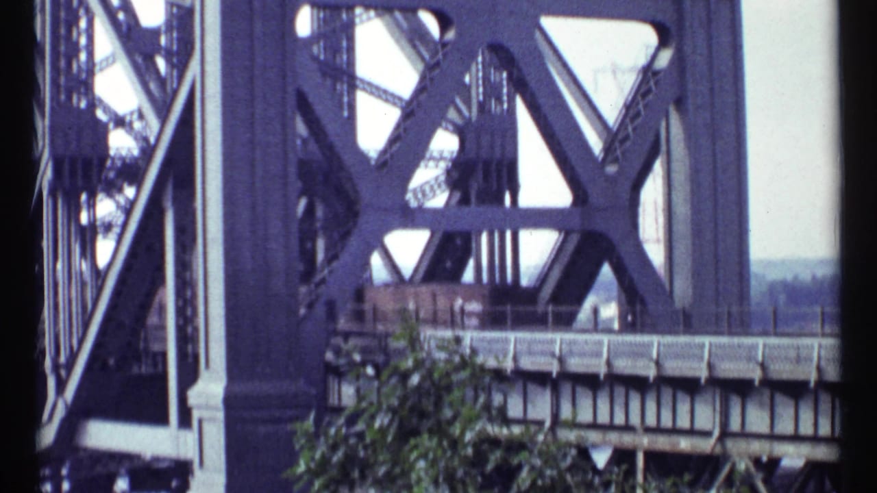 Steel bridge structure seen from a moving or handheld 8mm viewpoint.