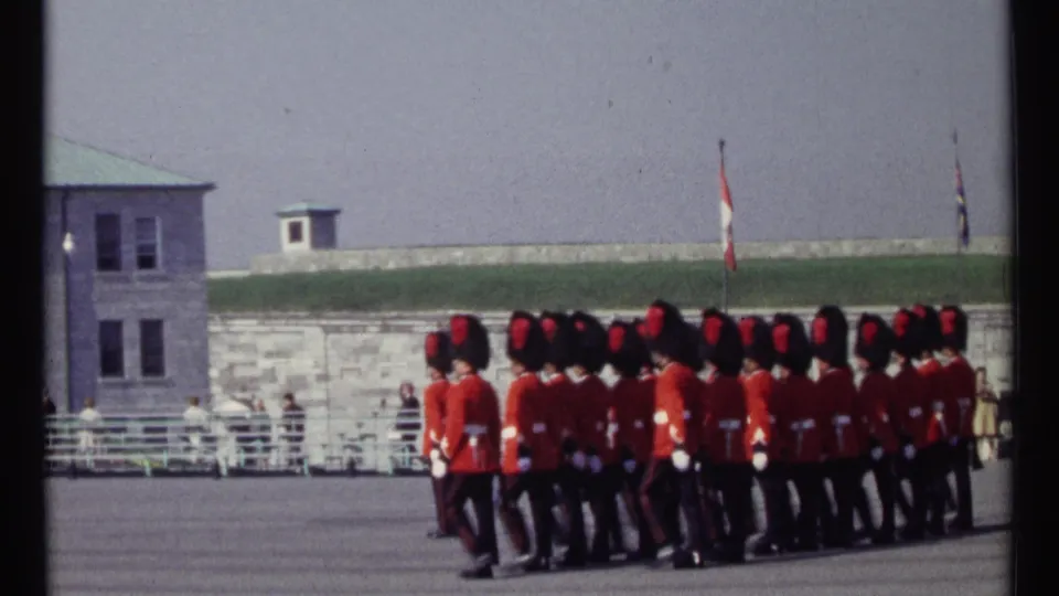 Canadian ceremonial guards march in formation across an Ottawa parade ground in this 1967 8mm home-movie frame.