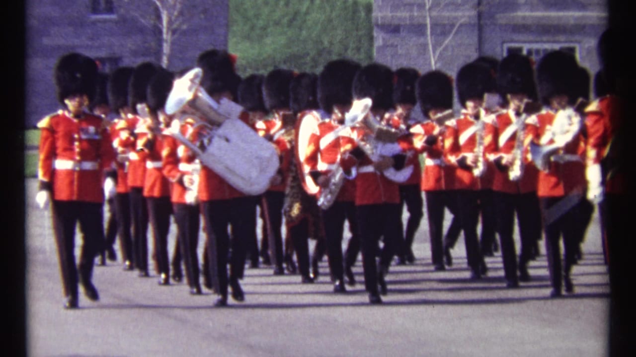 1967 Ottawa footage shows ceremonial guards in red tunics and tall black hats marching forward with brass and woodwind instruments.