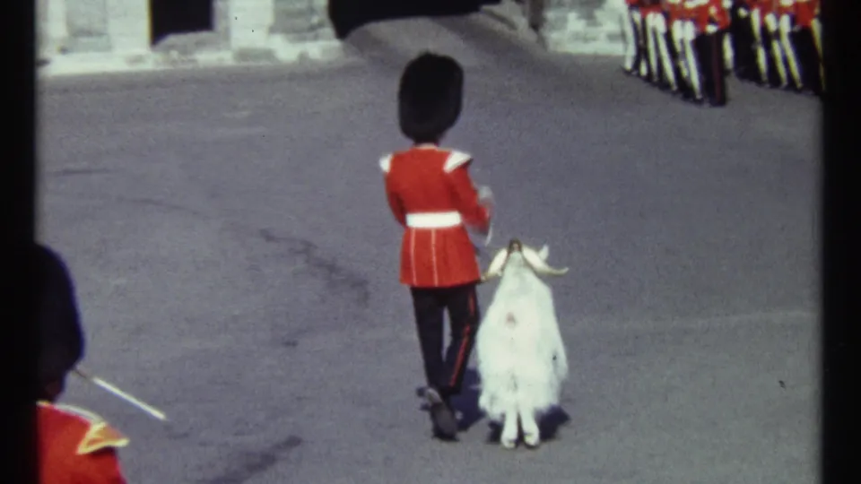 1967 Ottawa frame showing the guard and goat approaching a line of red-coated guards near stone architecture.