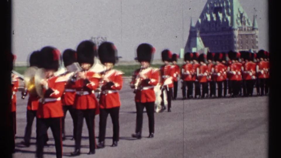 1967 Ottawa frame showing the marching band arranged across the plaza, with drums, brass, and a chateau-style building behind.
