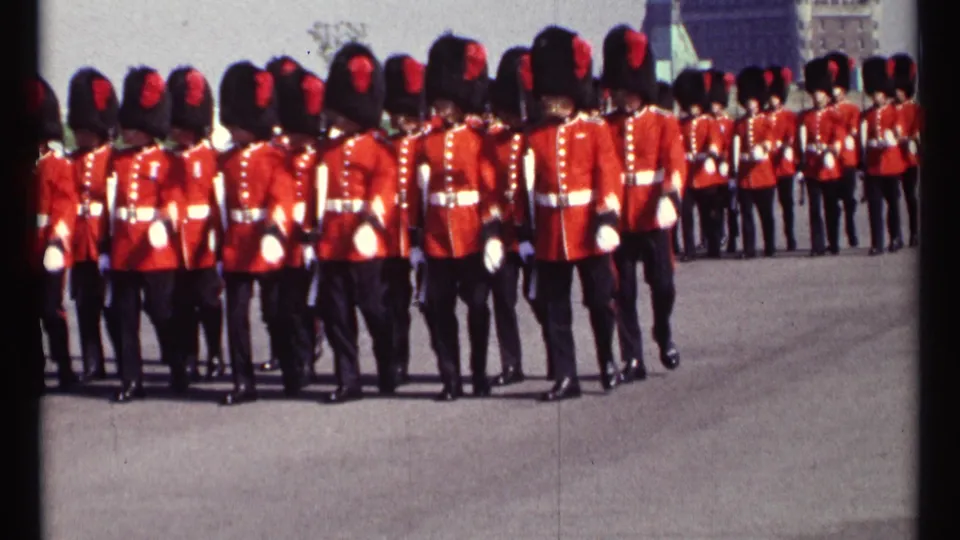A tight 1967 Ottawa view shows rows of red-coated guards marching away across the plaza in bright daylight.