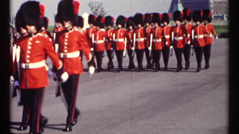 1967 Ottawa home-movie view of Canadian Guards marching away in orderly rows across a paved ceremonial area.