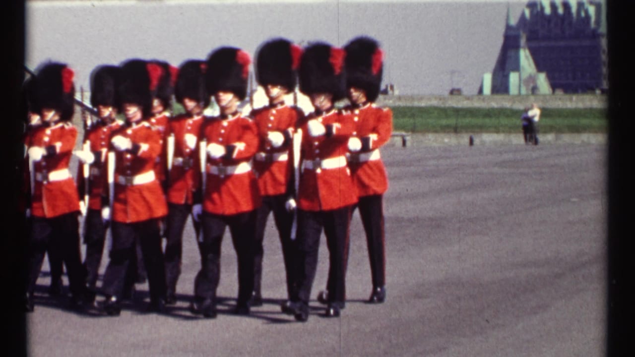 Ceremonial guards in red uniforms march with rifles held across their chests.