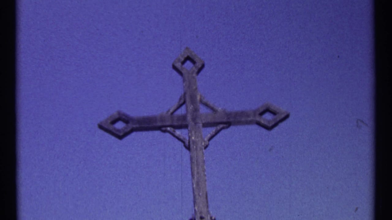 Metal cross top against blue sky, cropped near the lower edge.