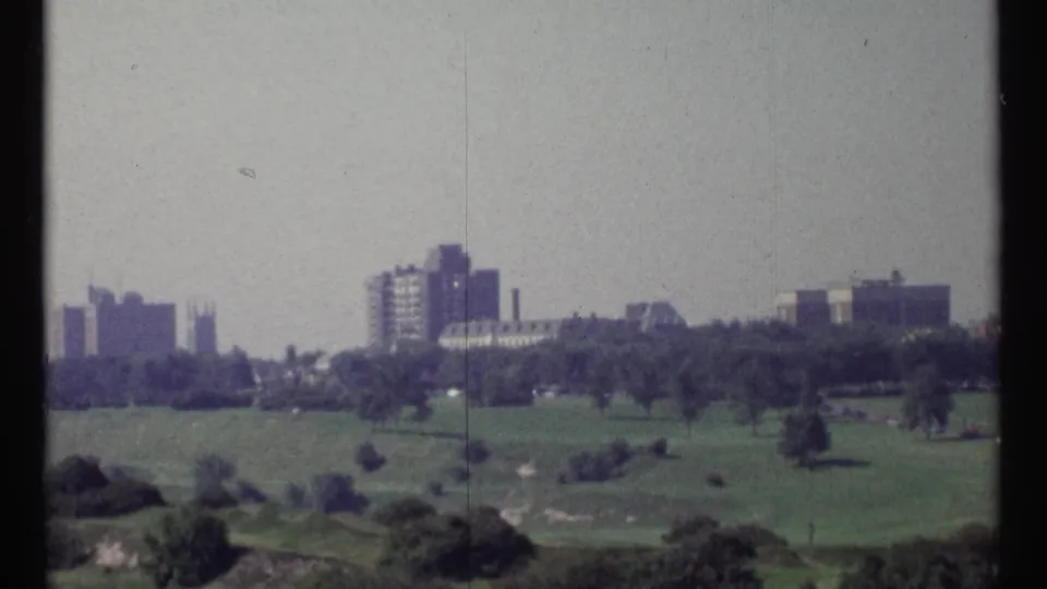 Elevated 1967 Ottawa view across open parkland toward apartment blocks and institutional-looking buildings.