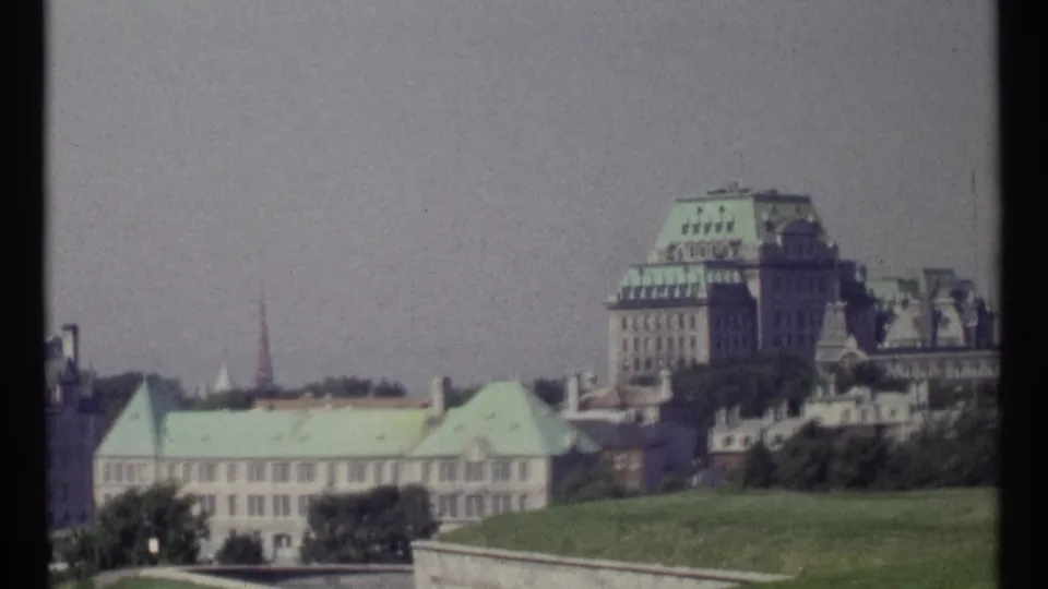 Ottawa 1967 frame with a large formal building, green roof, distant tower, trees, and a broad grassy foreground.