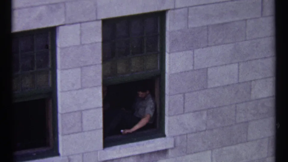 1967 Ottawa frame with a seated man partly visible at an open window set into a stone exterior wall.