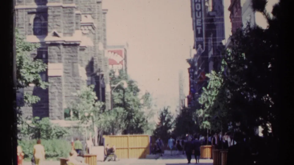 1967 Ottawa street footage with soft exposure, pedestrians, benches, trees, stone architecture, and a commercial sign.