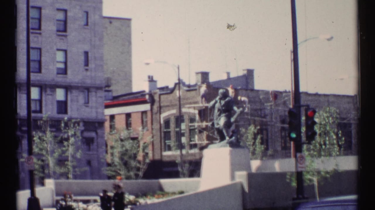1967 Ottawa street view with a civic statue, surrounding buildings, traffic signals, and planted foreground.
