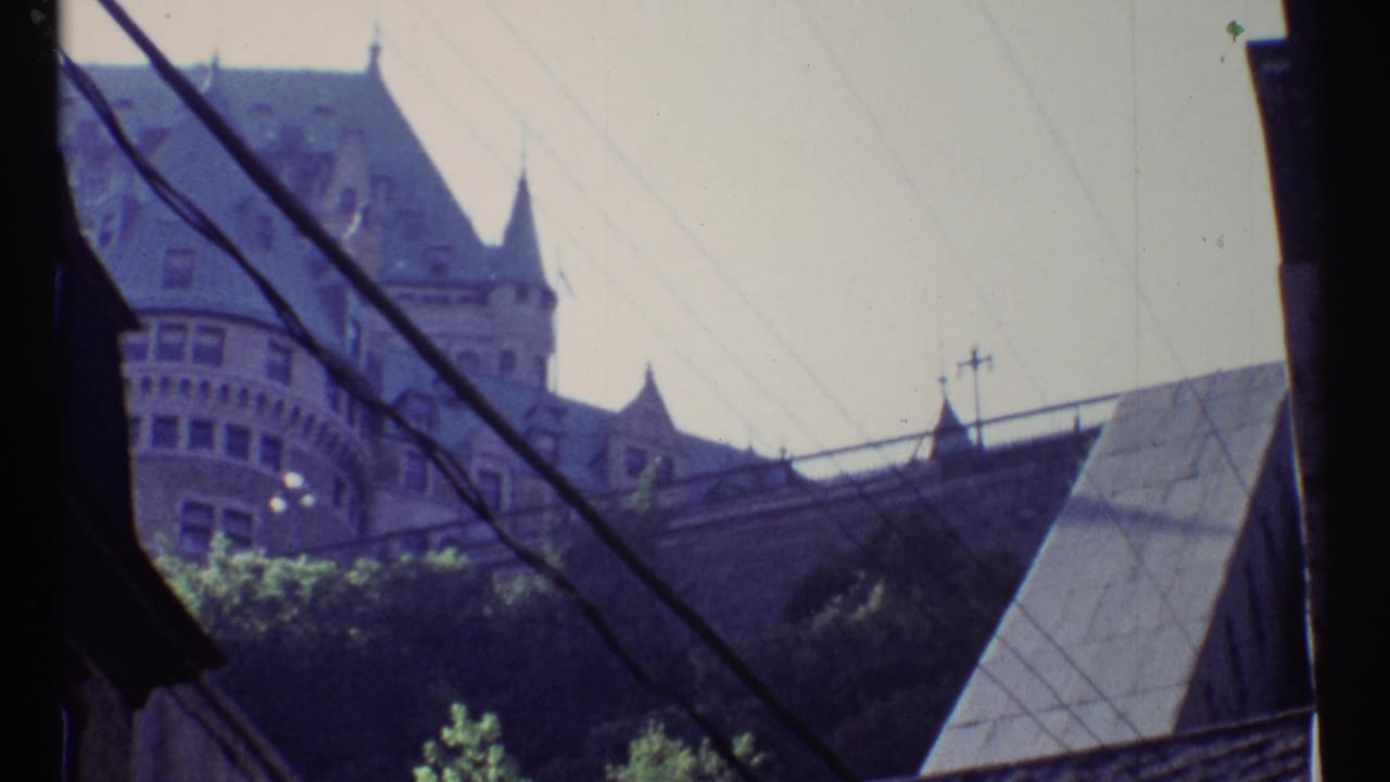 Ottawa 1967 8mm frame showing a castle-like building partly obscured by dark foreground framing and overhead wires.