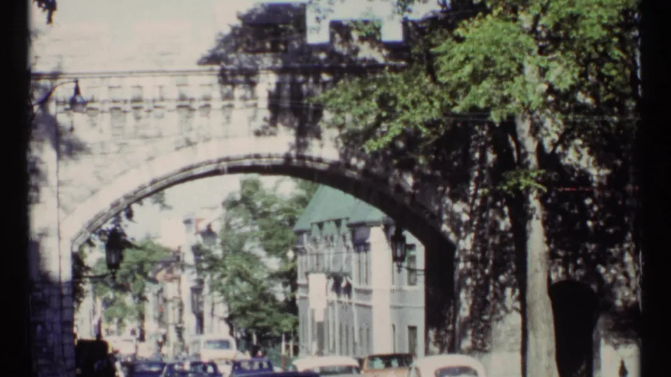 A 1967 Ottawa street scene shows classic cars and pedestrians beneath a broad stone bridge arch.