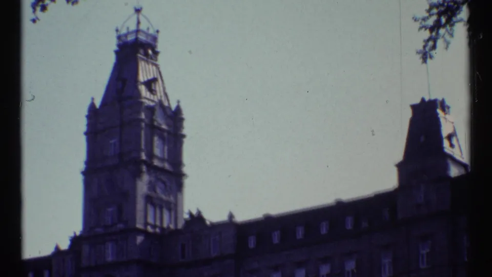 1967 Ottawa 8mm frame showing the clock tower in soft focus with the building's upper facade, dormer windows, and dark roofline below.