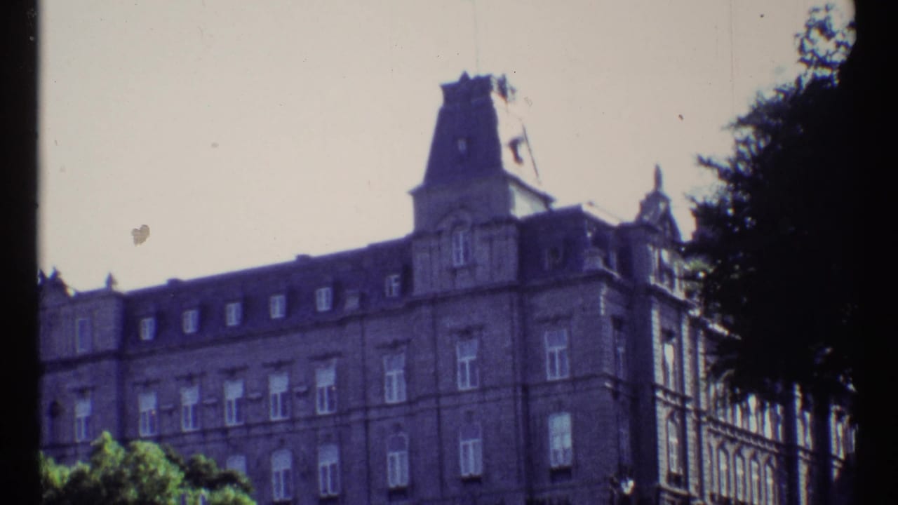 Ornate multi-story building with a central tower seen through soft 8mm color.