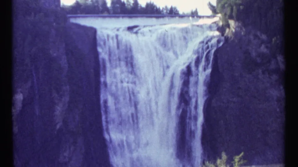 1967 Ottawa 8mm home-movie frame with the waterfall centered lower in the shot and dark rock walls on both sides.