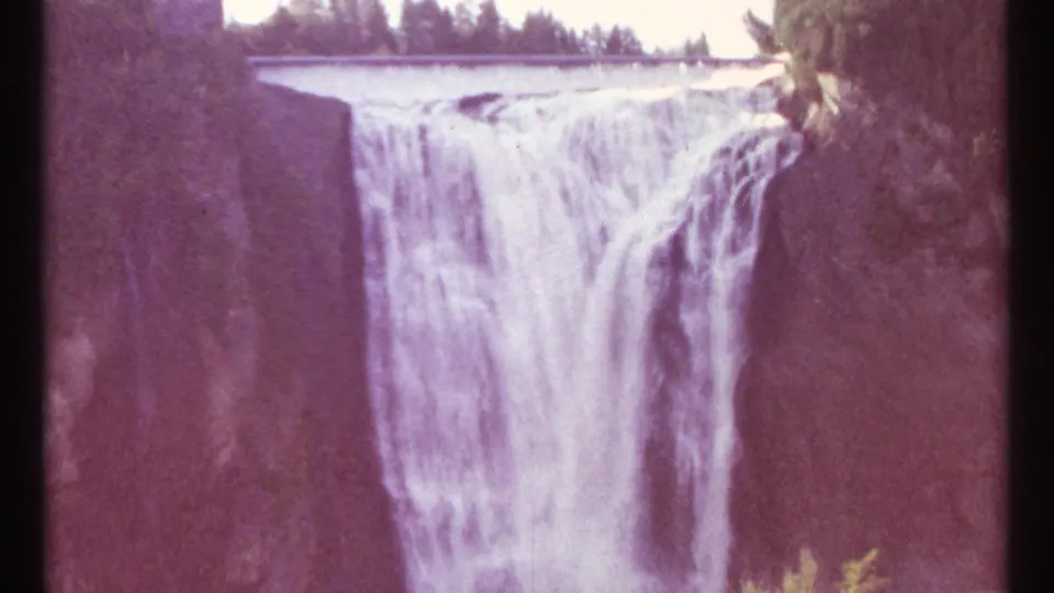 1967 8mm Ottawa waterfall view with a noticeable magenta-purple color shift across the rock and water.