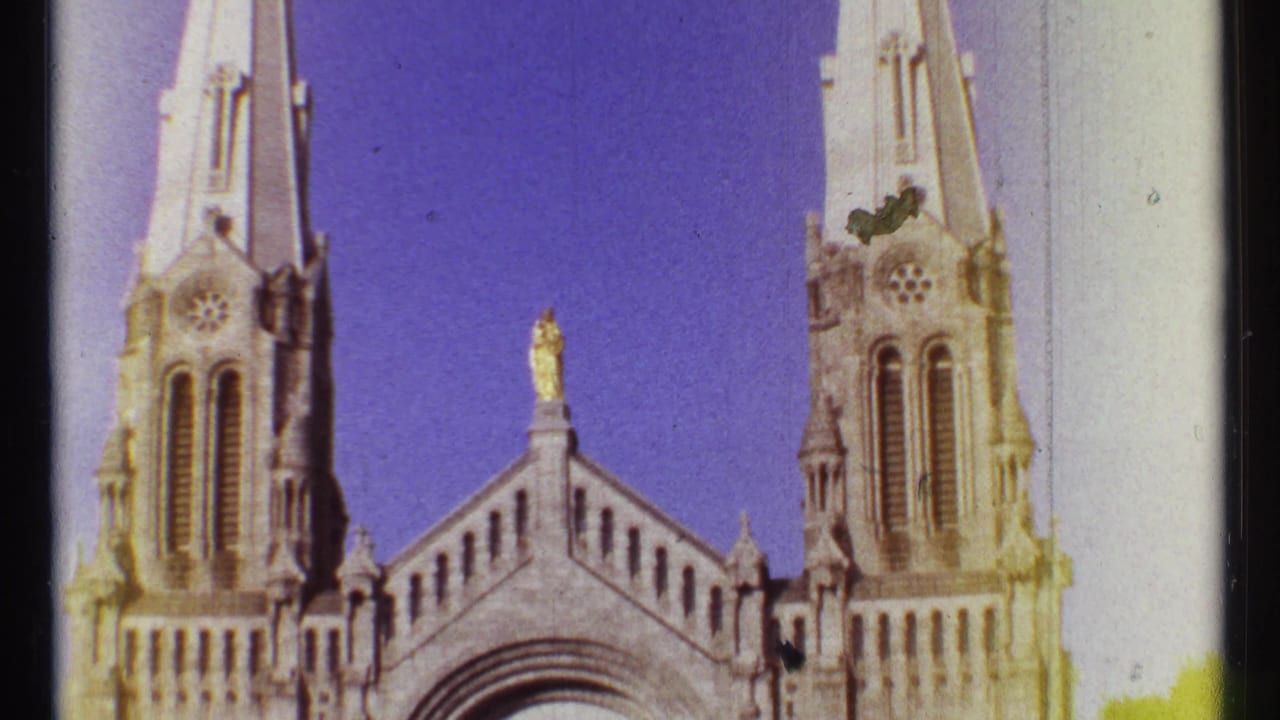 Church facade with twin Gothic towers and a central arched entrance under a purple-blue sky.