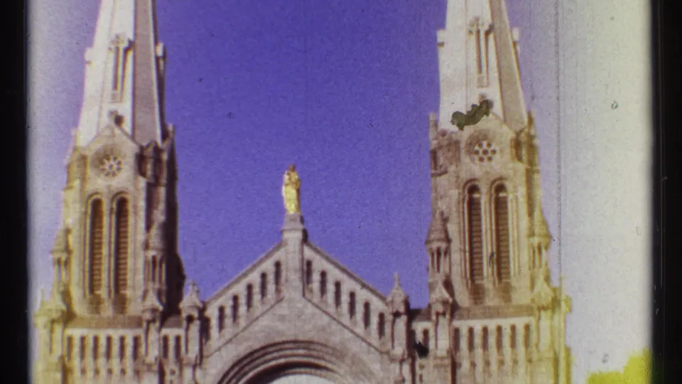 1967 Ottawa 8mm frame showing a church facade, twin spires, arched stonework, and a small gold rooftop figure.