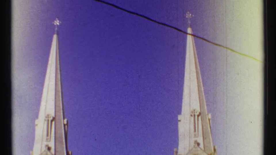 1967 Ottawa 8mm frame with paired church spires, cross tips, diagonal wire, and soft color-shifted sky.