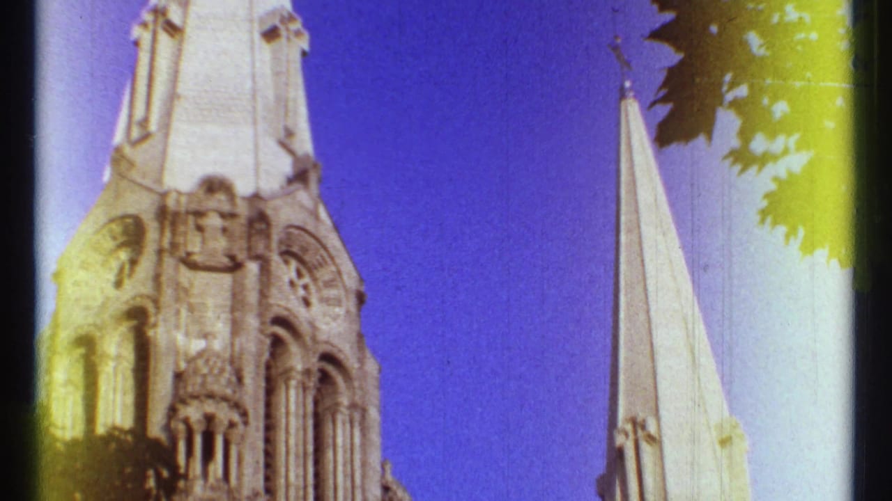 Low-angle view of pale cathedral spires against a blue sky.