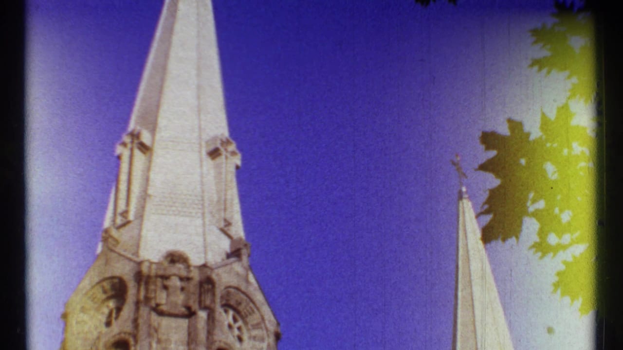 Ottawa 1967 frame with a pale church steeple, smaller spire, silhouetted leaves, and yellow-green film-edge flare.