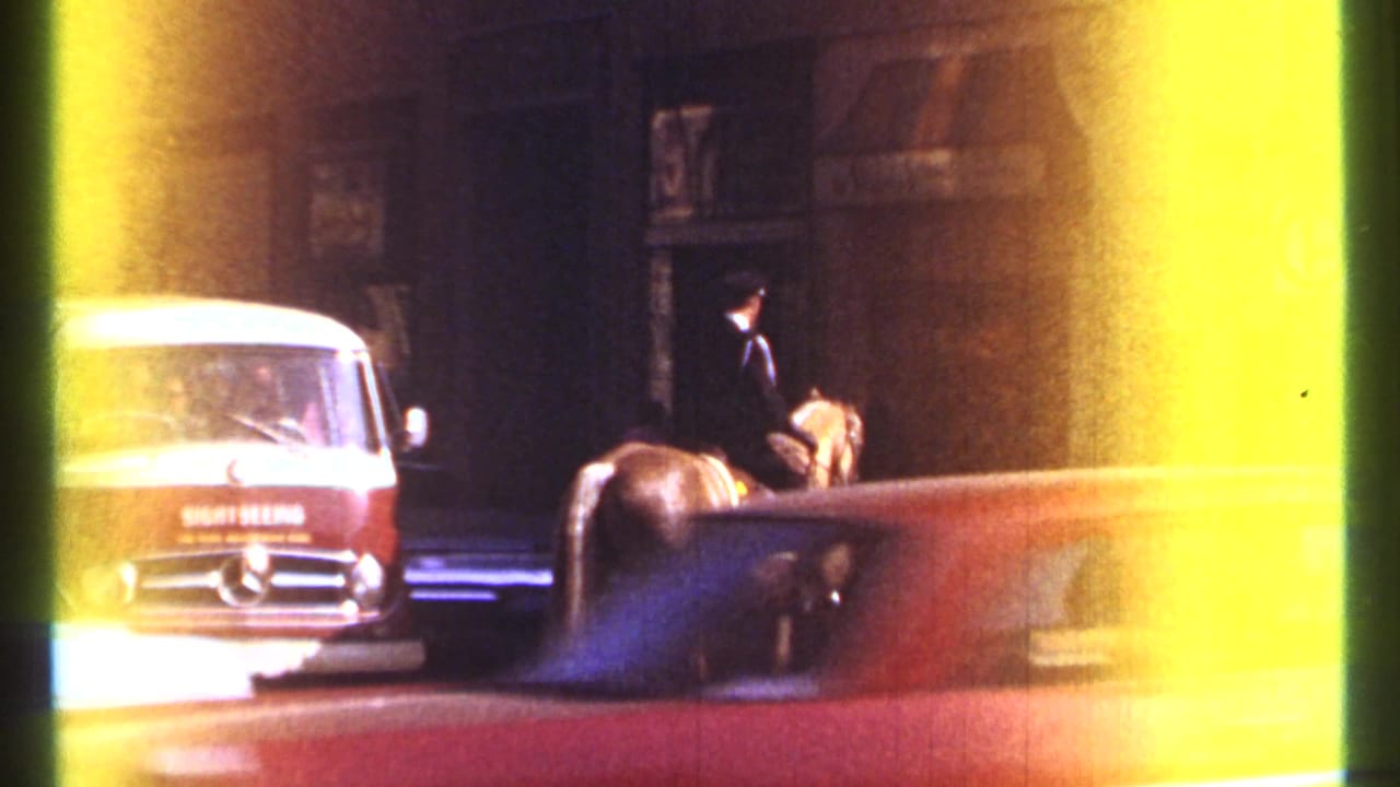 1967 Ottawa frame showing a mounted officer on horseback near a red and white Mercedes-Benz van and a passing or parked car.