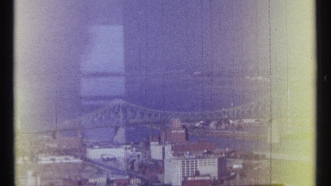 Hazy elevated view of a river bridge and Ottawa city buildings on aged film.