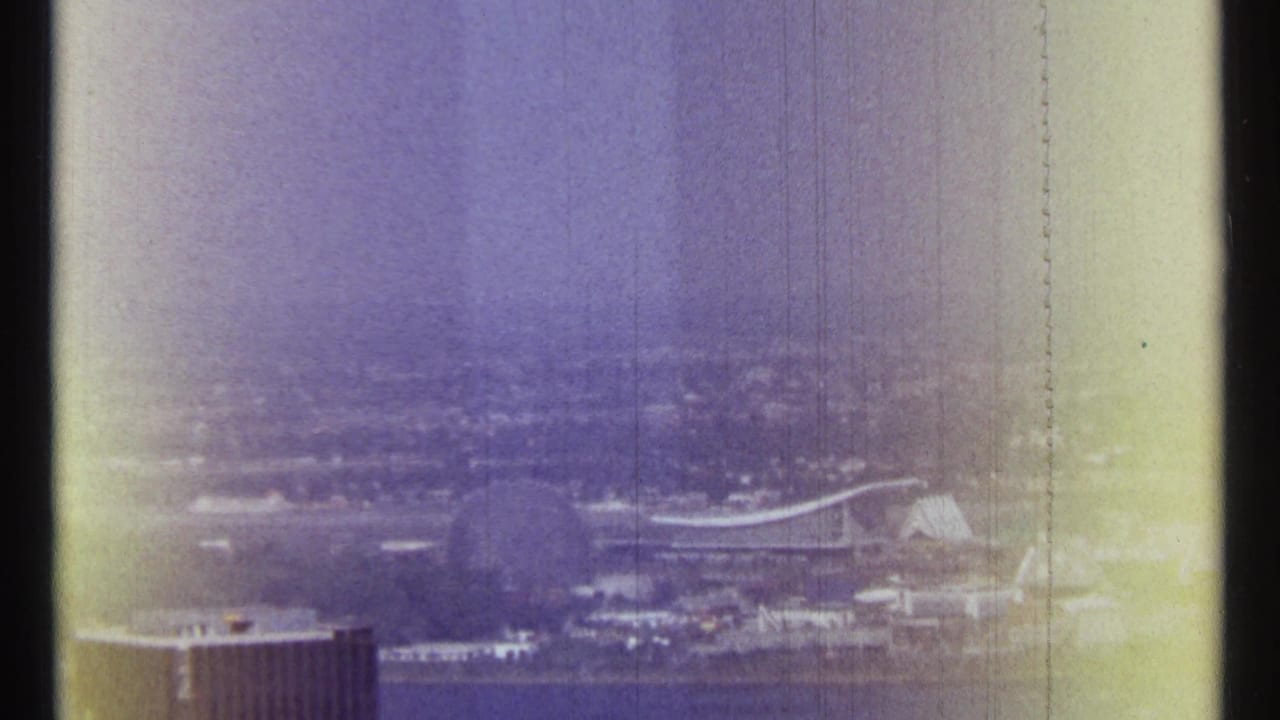 Distant cityscape with riverfront, curved-roof structure, and visible film borders.