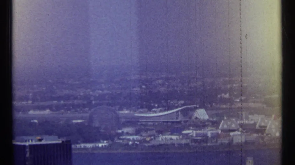 1967 Ottawa frame showing the riverfront cityscape, a curved-roof structure, a dark foreground building, and prominent 8mm film grain.