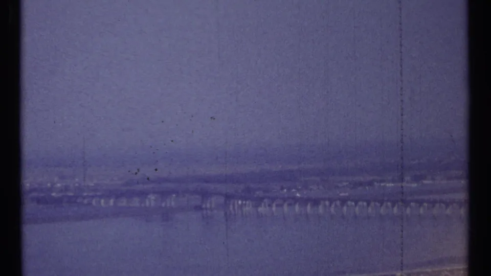 Hazy 1967 Ottawa bridge footage, showing a distant span over water with grain, scratches, and scan-edge artifacts.