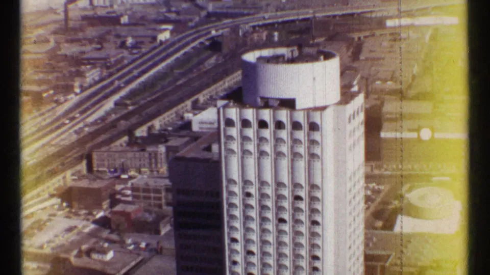 1967 Ottawa aerial view showing the high-rise from above, adjacent blocks, transport lines, and visible 8mm color fading at the frame edge.