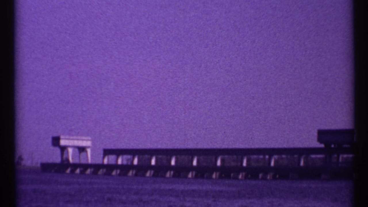 1967 Toronto home-movie frame with a low bridge-like structure extending across water and a small block-like feature on top.