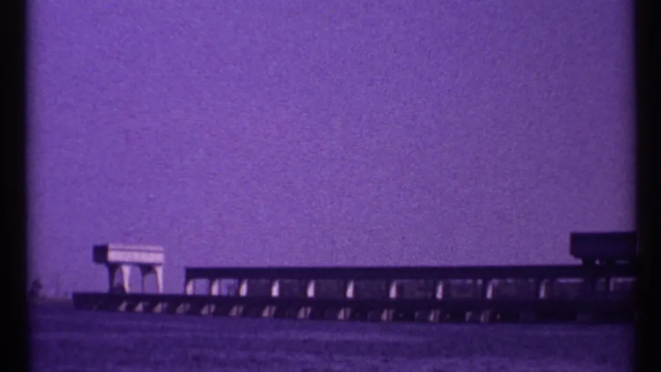 1967 Toronto home-movie frame with a low bridge-like structure extending across water and a small block-like feature on top.