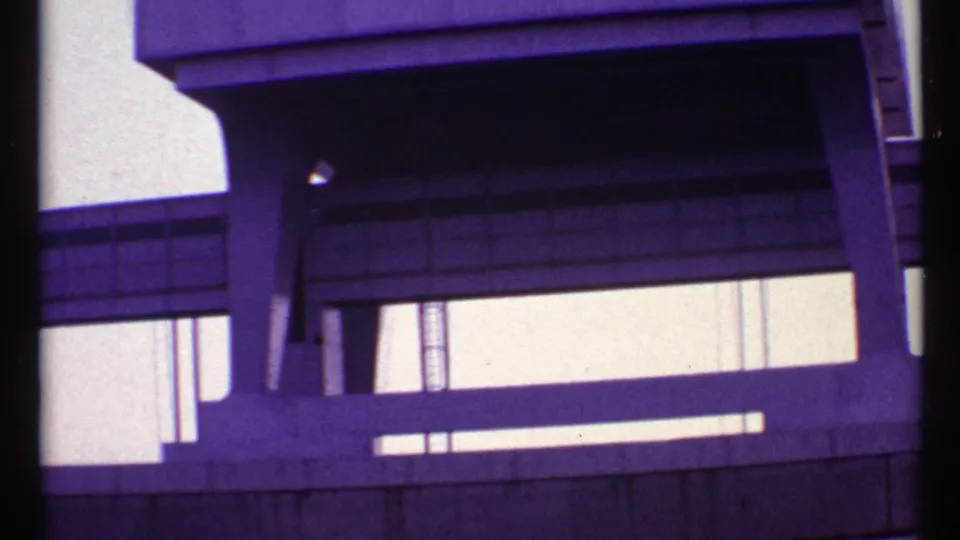 1967 Toronto 8mm frame of a bridge-like concrete waterway structure, showing angled supports and bright gaps beneath the span.