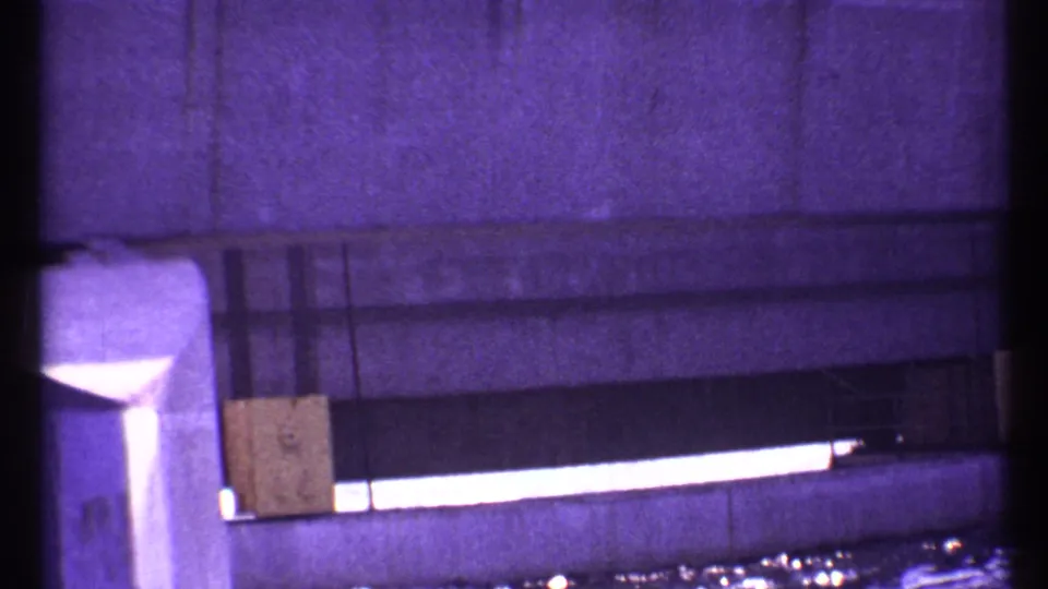 1967 Toronto 8mm frame showing a close, purple-tinted view of concrete structure detail and a bright horizontal gap above water.