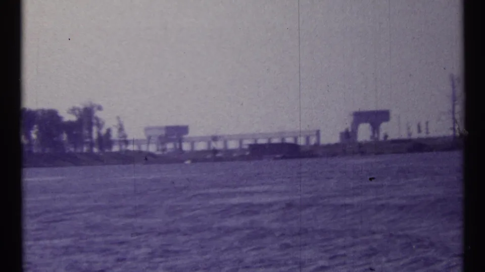 1967 8mm frame from a moving boat showing open water and distant waterfront structures in the Toronto clip metadata.