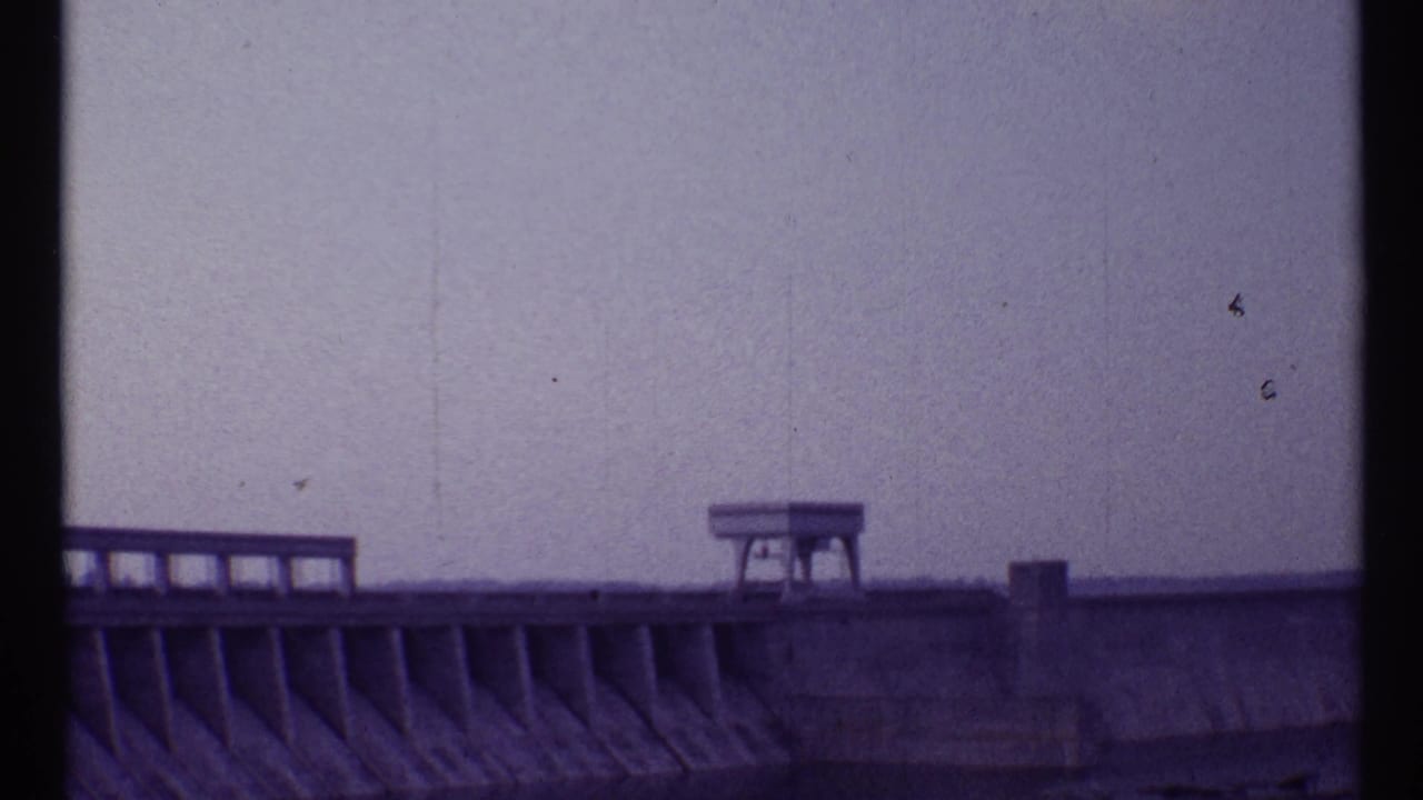 Concrete stadium or dam-like structure under pale sky.
