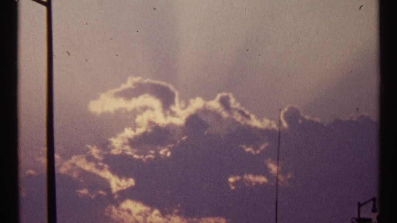 Purple-toned clouds with bright sunlit edges behind vertical dark bars.